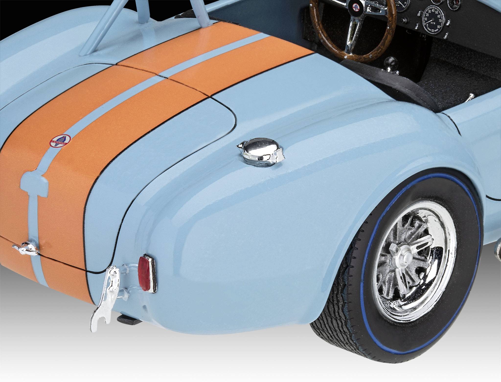 Voiture jouet bleue avec des rayures oranges. Côté droit et roue arrière visibles. Intérieur avec volant et tableau de bord.