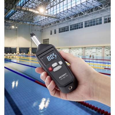 Un appareil portable affiche une valeur de 80,5 au-dessus d'une piscine. L'appareil pourrait mesurer des paramètres liés à l'eau ou à l'environnement.