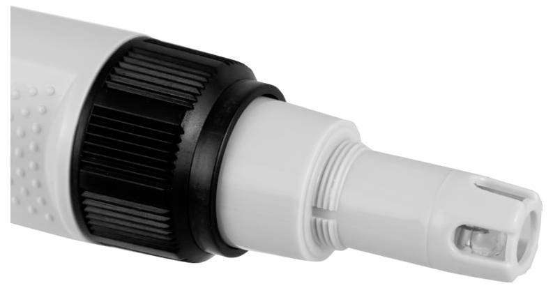 Gros plan d'une pointe de dispositif médical en plastique blanc et noir avec un capuchon transparent, montré sur un fond uni.