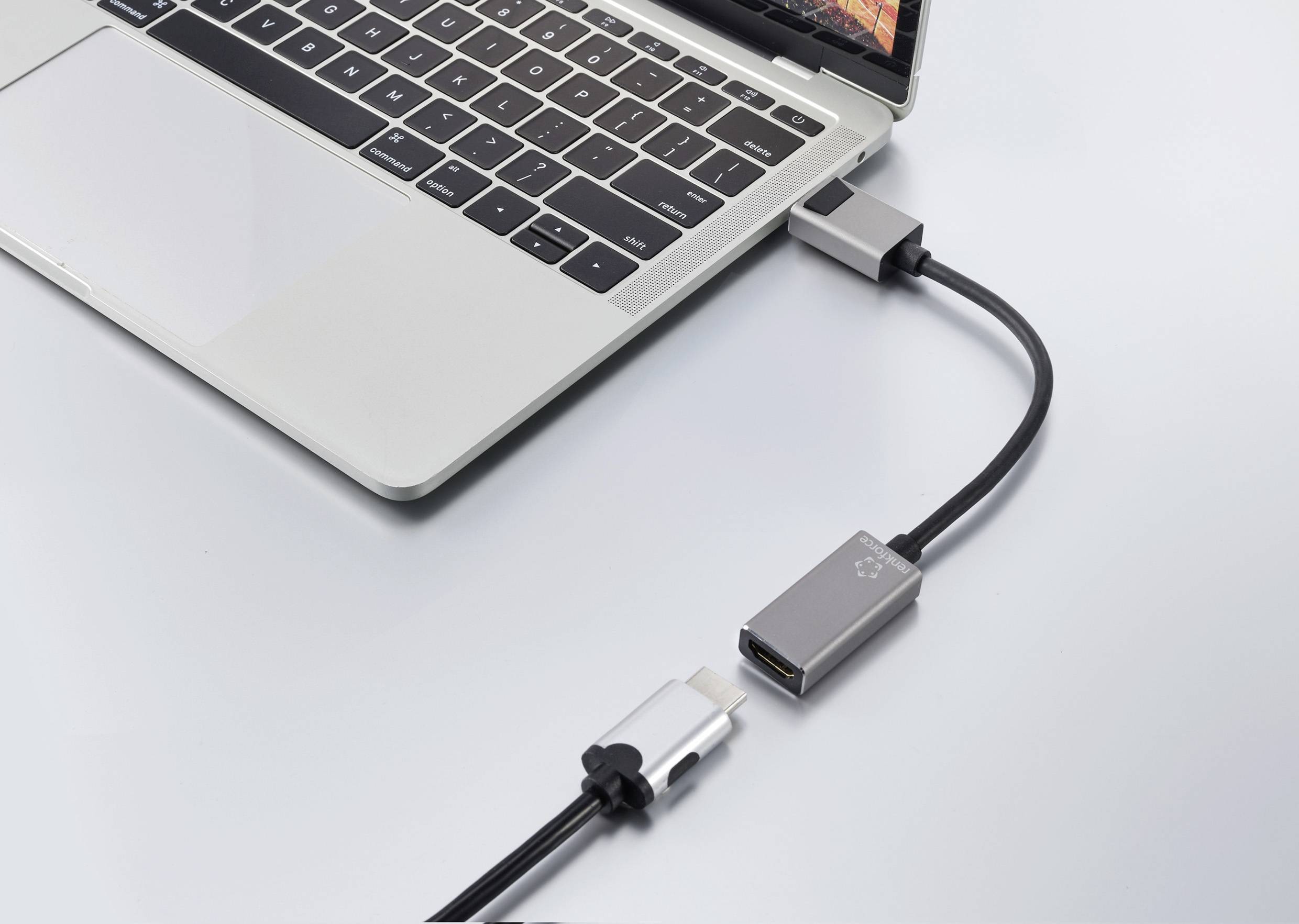 Un ordinateur portable avec un adaptateur HDMI connecté à un port USB-C. Un câble HDMI est branché à l'adaptateur.