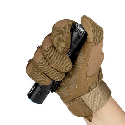 Une main gantée tient une lampe de poche noire avec un bouton bleu, le pouce appuyant sur l'interrupteur.