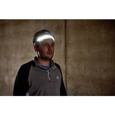 Un homme en tenue de sport porte un bandeau lumineux dans une pièce sombre.