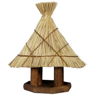Une maisonnette pour oiseaux rustique avec un toit en roseau, dans un style traditionnel. Elle repose sur un support en bois à quatre colonnes.