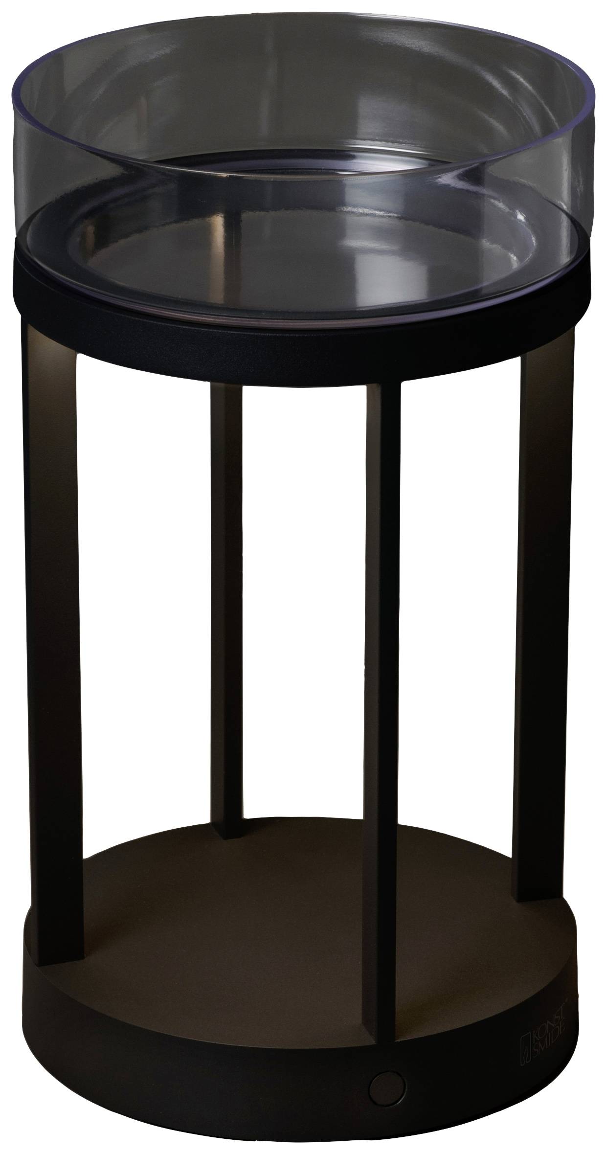 Lampe de table à finition noir mat avec un abat-jour cylindrique en verre, reposant sur trois pieds métalliques fins. Design minimaliste.