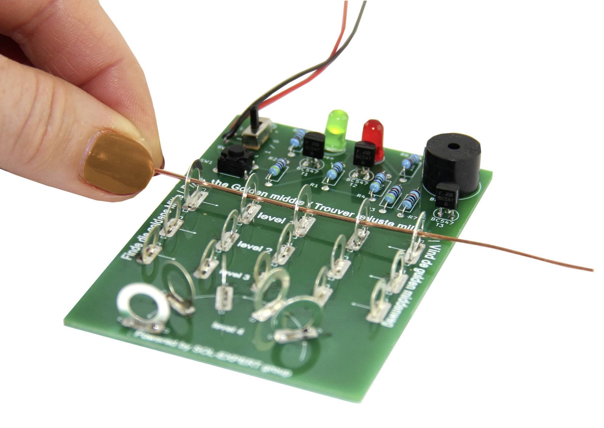 Une main tient un fil au-dessus d'une carte électronique verte avec des LEDs et des composants. Les LEDs brillent en rouge et en vert.