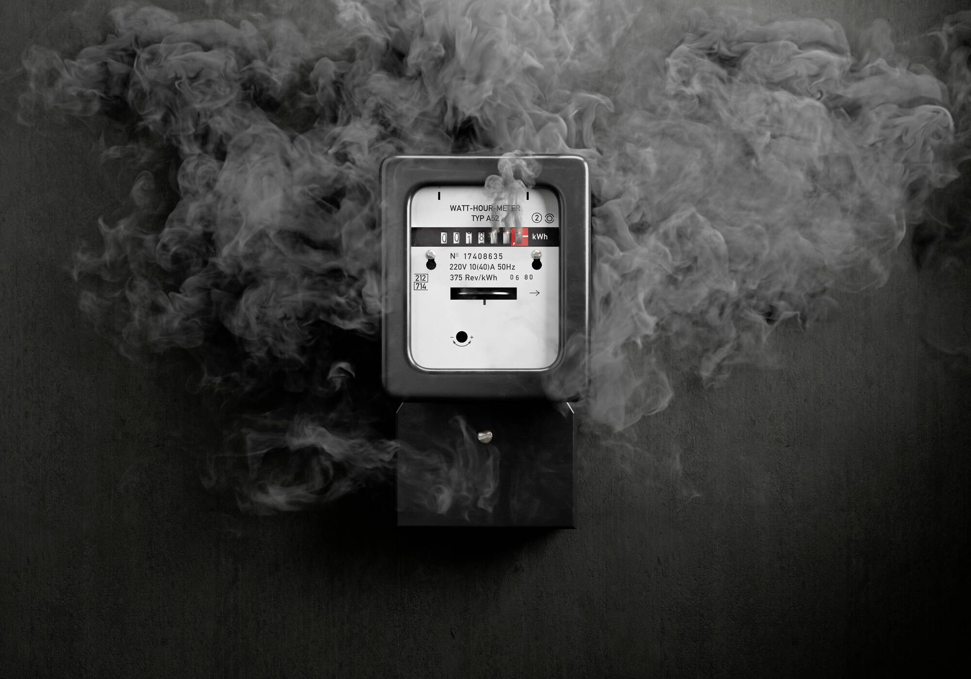 Un compteur électrique entouré de fumée. La fumée suggère potentiellement un problème ou un danger lié à l'appareil.
