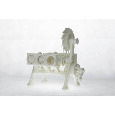 Un modèle blanc en plastique d'un moteur avec des cylindres, des engrenages et une roue de ventilateur visibles. Le modèle est posé sur une table.