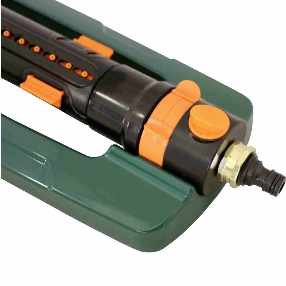 Arroseur de jardin réglable en plastique vert et orange, adapté à l'irrigation uniforme des surfaces enherbées.