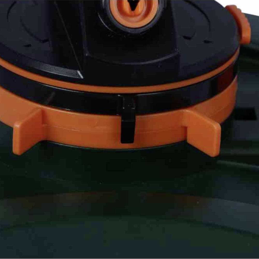 Gros plan d'une valve en plastique orange et noir sur un fond vert.