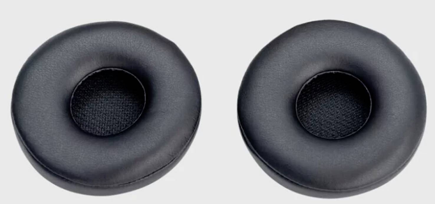 Deux coussinets d'écouteurs noirs en cuir avec une mousse douce, posés côte à côte sur une surface grise.