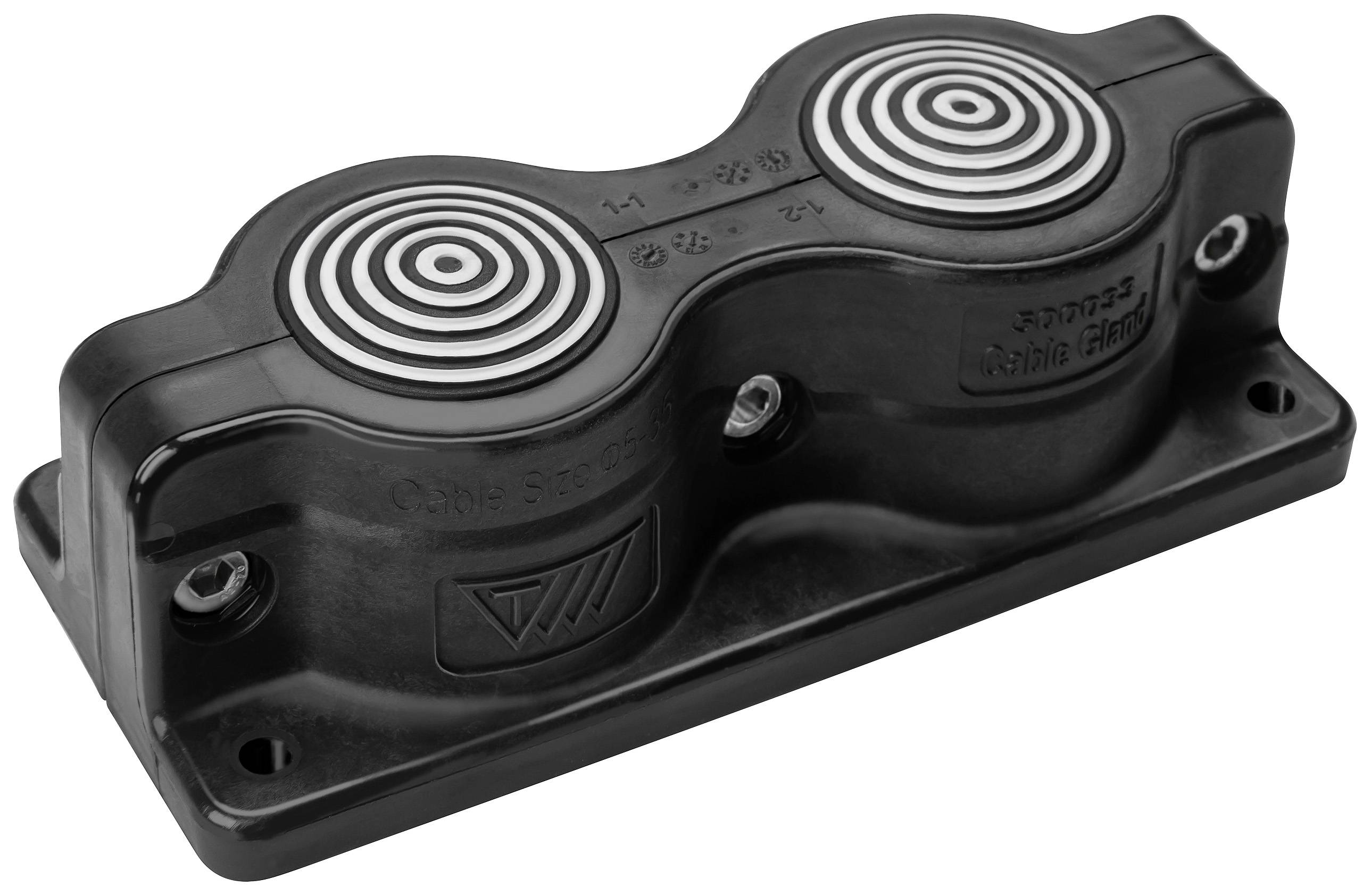 Un composant rectangulaire noir en plastique avec deux éléments métalliques circulaires sur sa surface supérieure, probablement un aimant.