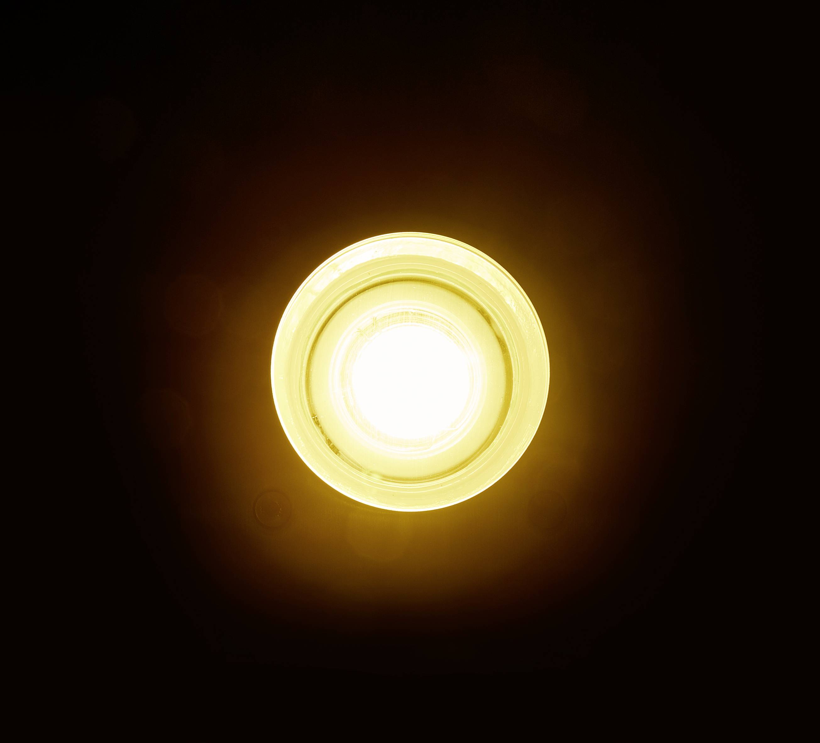 Une ampoule lumineuse brille intensément dans un environnement sombre.