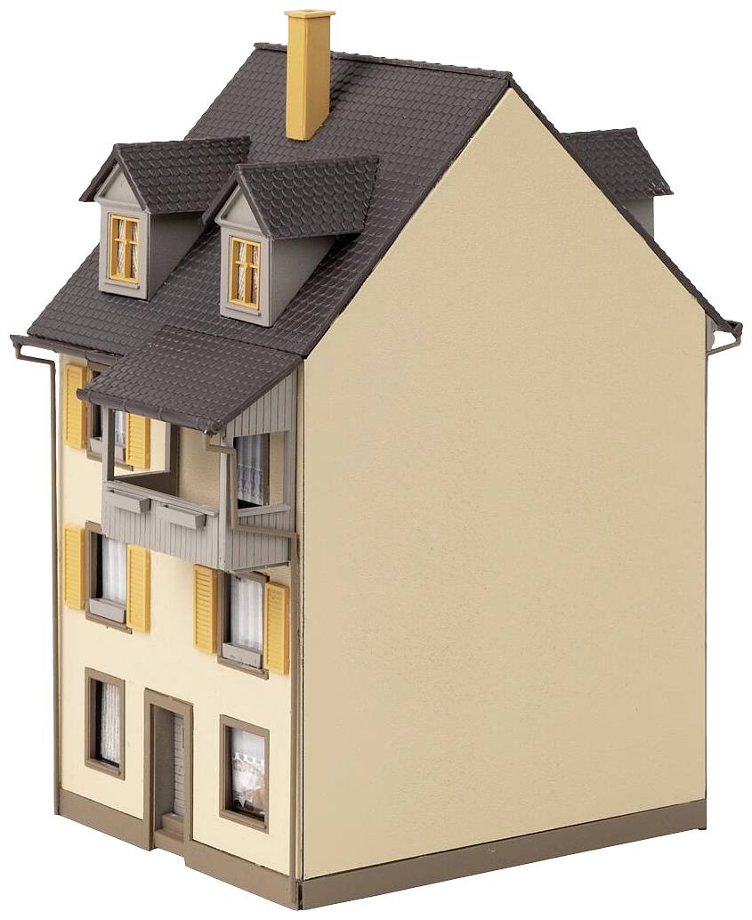 Une petite maison miniature riche en détails, aux murs beiges, avec plusieurs fenêtres et un toit à deux pans de couleur gris foncé.