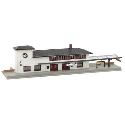 Un modèle d'une gare à deux étages, avec une tour surmontée d'une horloge, deux entrées et un quai couvert. Un panneau indique 'Freibach'.