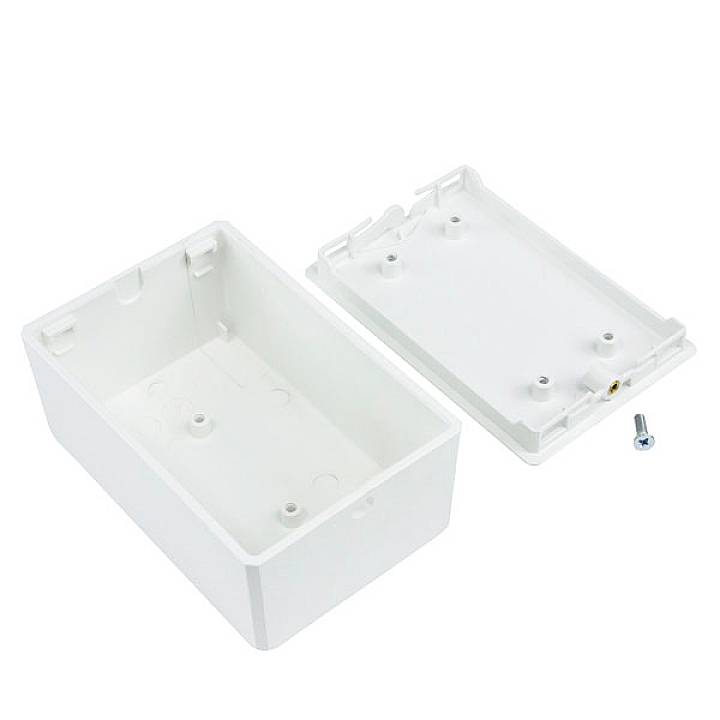Boîte en plastique blanc avec son couvercle retiré et une petite vis à côté, vue d'en haut.