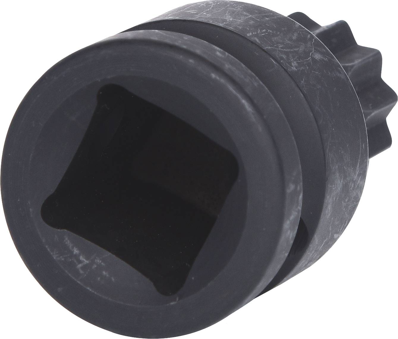 Une pièce métallique noire cylindrique avec un bord dentelé et une ouverture carrée au centre, probablement un adaptateur ou un accessoire.