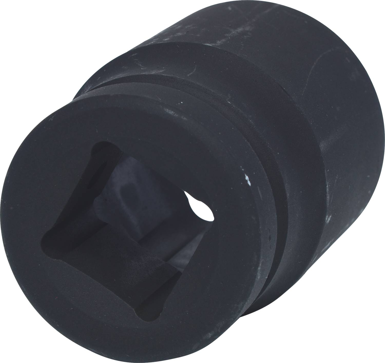 Un accessoire d'outil en métal noir avec un espace intérieur carré et une surface extérieure ronde, utilisé pour des travaux de fixation mécaniques.