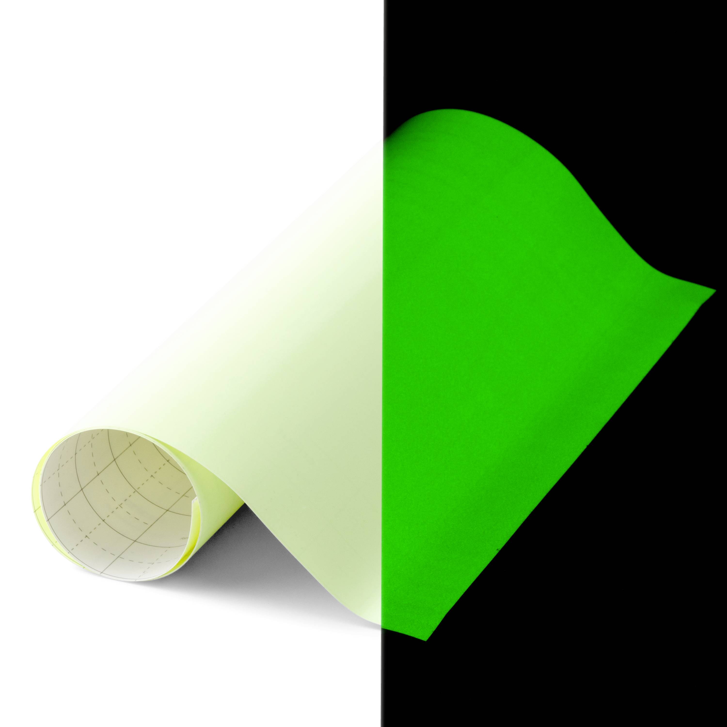 Une feuille en papier vert vif et blanc est à moitié enroulée, sur un fond noir et blanc, montrant une délimitation.