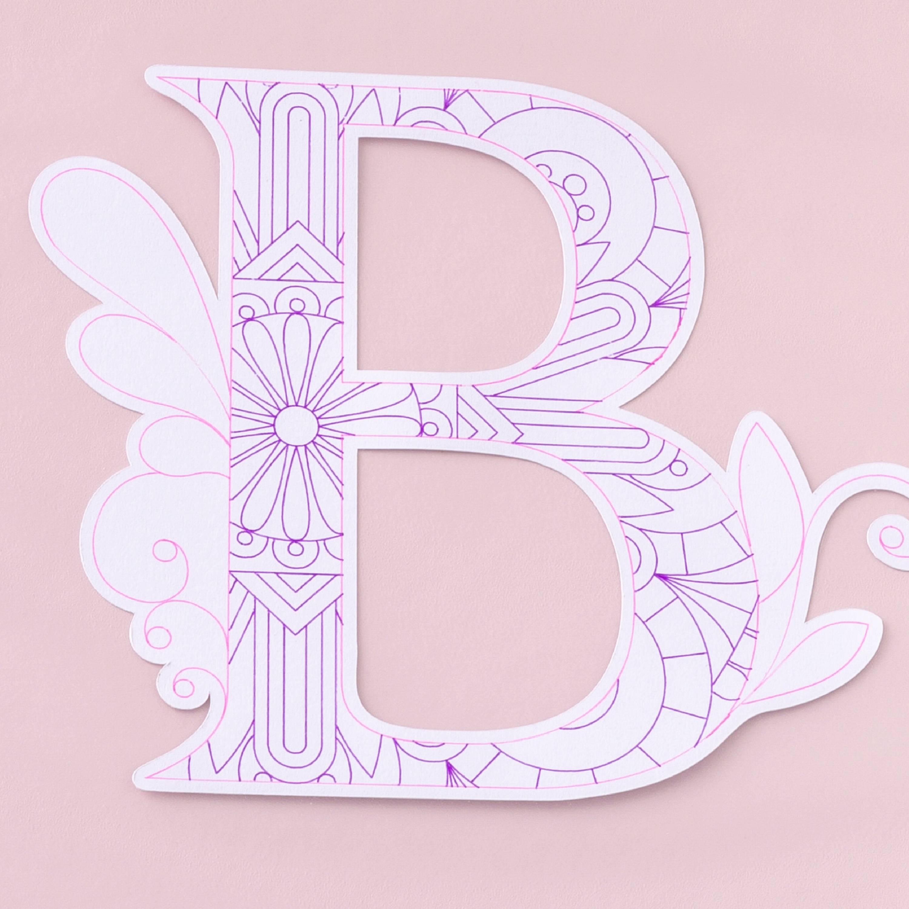 Une lettre 'B' ornementale en rose sur un fond rose pâle. Le design comprend des motifs floraux décoratifs.