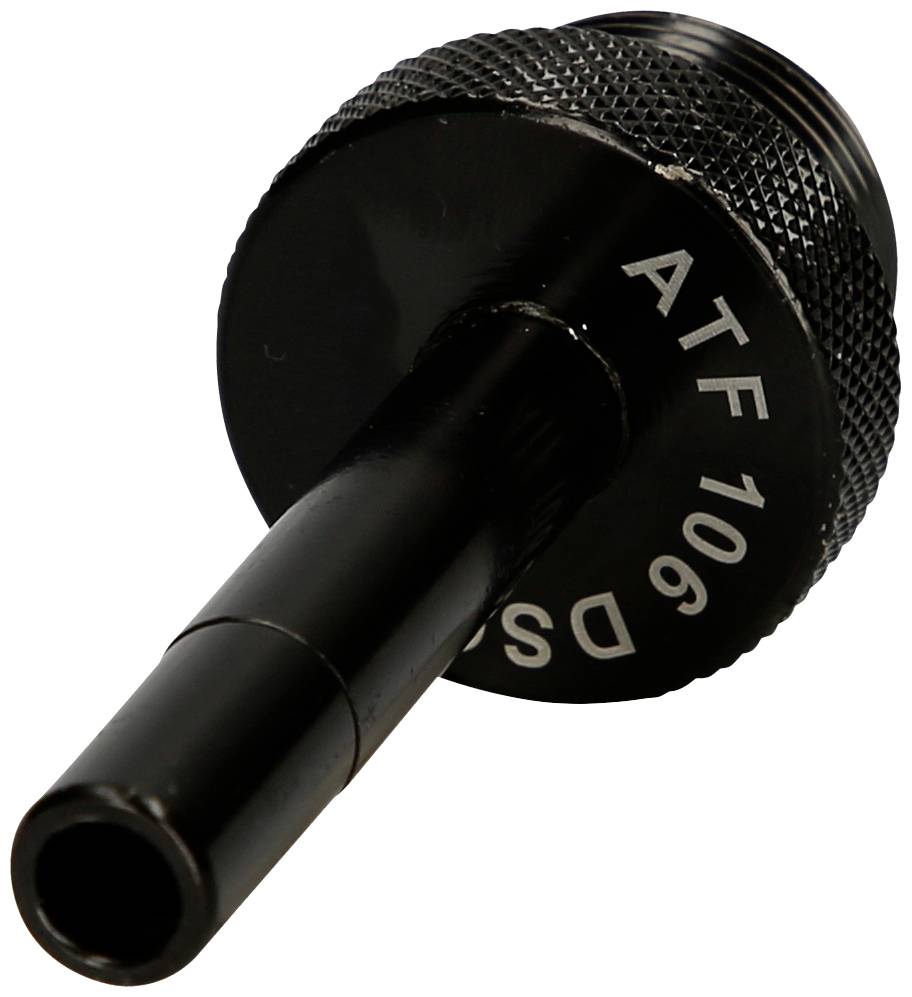 Pièce métallique noire avec col cylindrique, gravée sur le côté avec 'ATF 106'. Probablement un accessoire technique, gros plan.