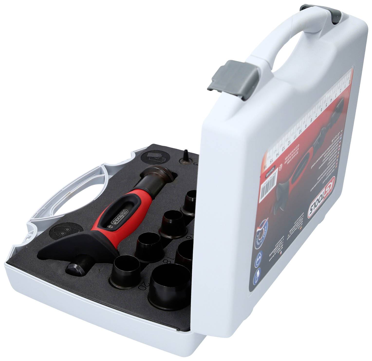 Valise en plastique avec couvercle ouvert montrant un marteau et plusieurs supports noirs. Emballage pour un ensemble d'outils.