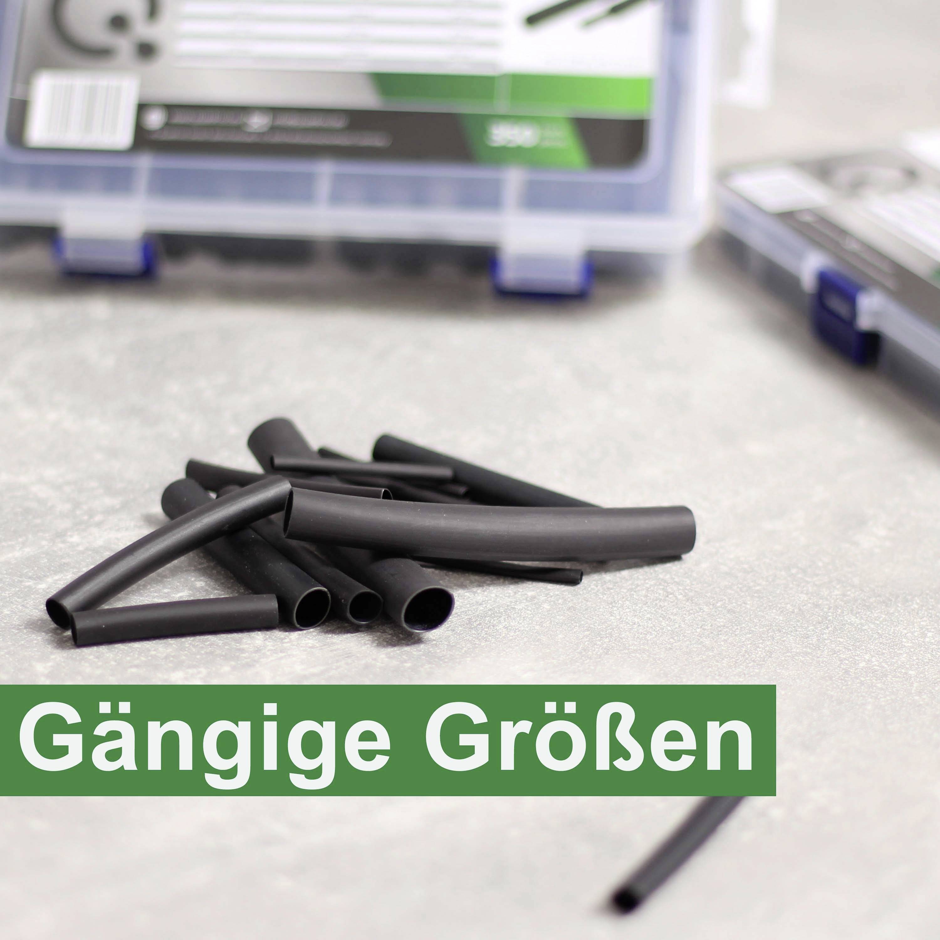 Des gaines thermorétractables noires de différentes tailles sont posées sur une table. À l'arrière-plan, une boîte ouverte contenant des gaines similaires est visible.