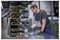Un technicien utilisant une perceuse sans fil Bosch pour assembler un rack d'équipement métallique dans un atelier.