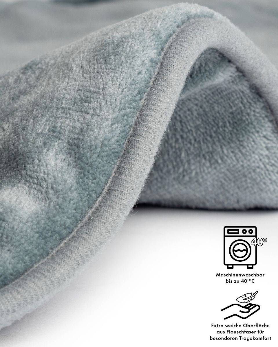 Un chiffon doux, plissé, de couleur gris-bleu. Il est lavable en machine jusqu'à 40 degrés. En dessous est inscrit : « Surface ultra-douce en fibre polaire pour un confort de port exceptionnel ».