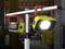 Deux lampes de travail LED portables sur un support métallique dans un atelier. L'une des lampes est allumée et brille intensément.