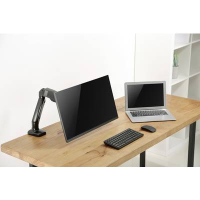 Un bureau avec un ordinateur portable, un grand écran monté sur un bras articulé, un clavier et une souris.