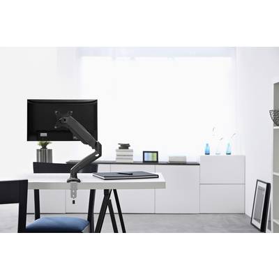 Espace de travail moderne avec un moniteur noir sur un bras articulé. Meubles et décoration blancs en arrière-plan. Intérieur lumineux et minimaliste.