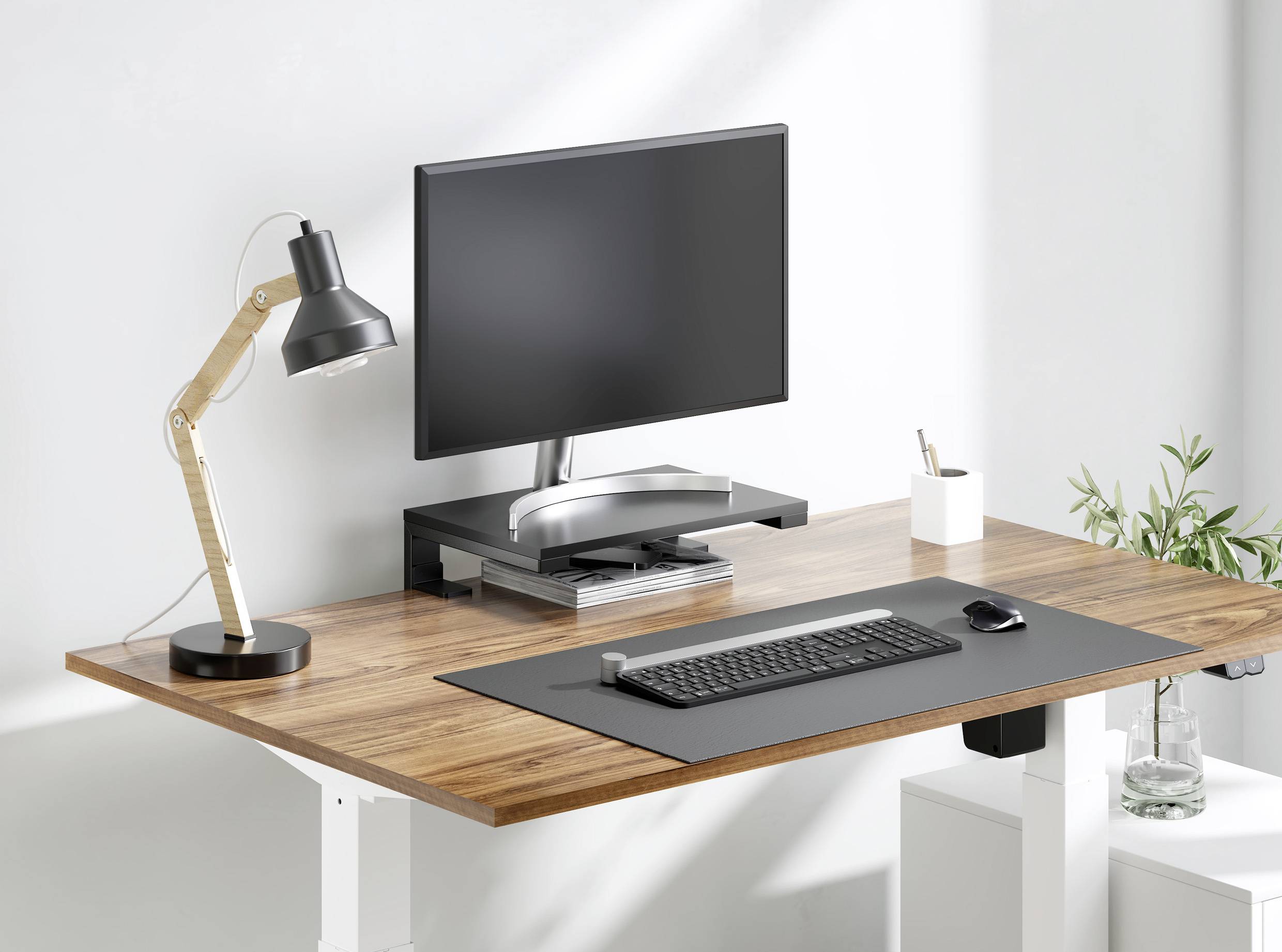 Bureau moderne avec écran, clavier, souris, lampe et plantes. Environnement de travail professionnel avec surface en bois naturel.