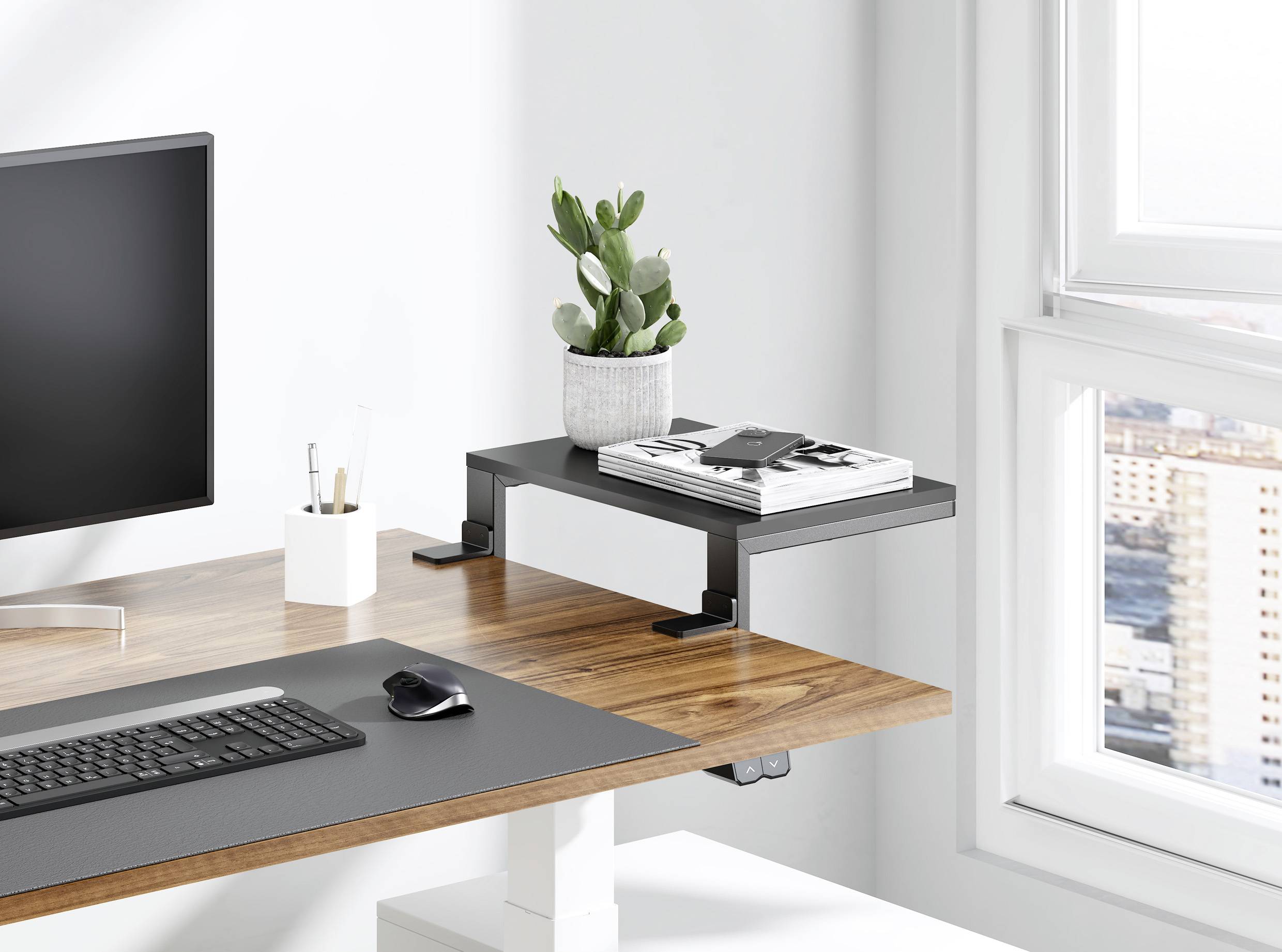Un bureau moderne avec un plateau en bois, sur lequel se trouvent un écran, un clavier, une souris et un support à plantes avec un cactus. Vue extérieure en arrière-plan.