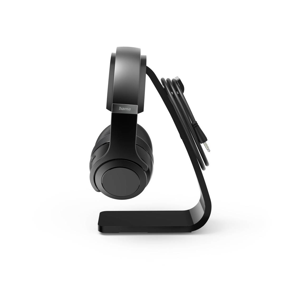 Casque audio posé sur un support noir solide, avec le câble soigneusement enroulé. Style moderne et minimaliste.