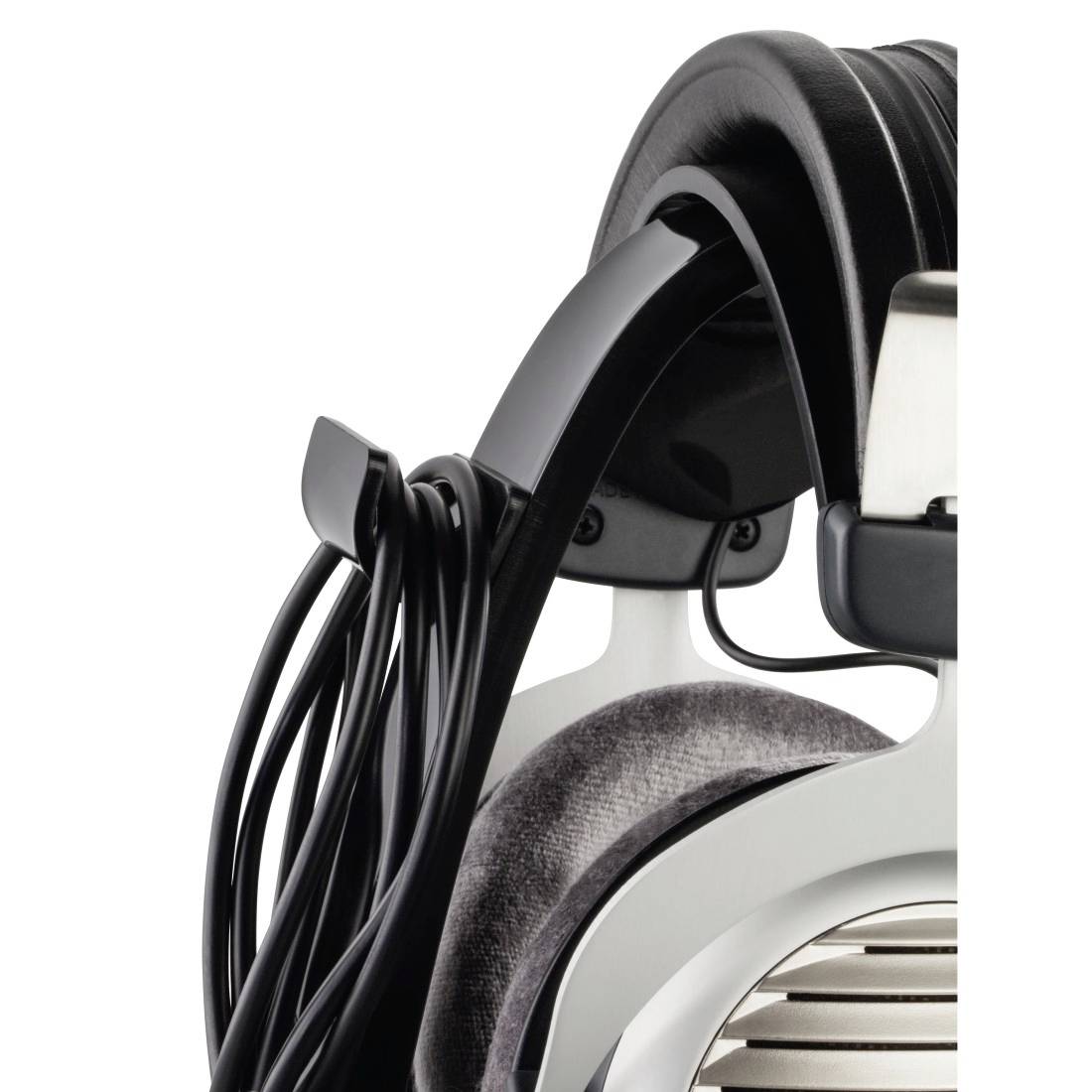 Gros plan sur un casque audio circumaural avec arceau noir et coussinets d'oreilles rembourrés, câble pendant sur le côté.