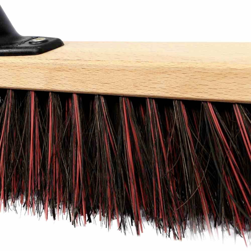 Gros plan d'un balai à manche en bois et poils noirs. Idéal pour une utilisation sur des surfaces dures ou en extérieur.