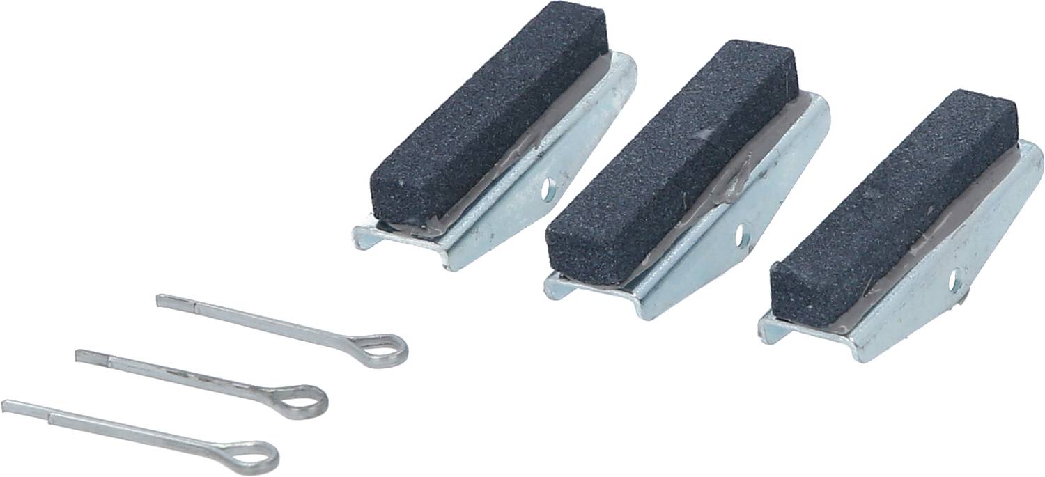 Trois plaquettes de frein noires avec des supports métalliques et deux goupilles de sécurité à côté, sur un fond blanc.