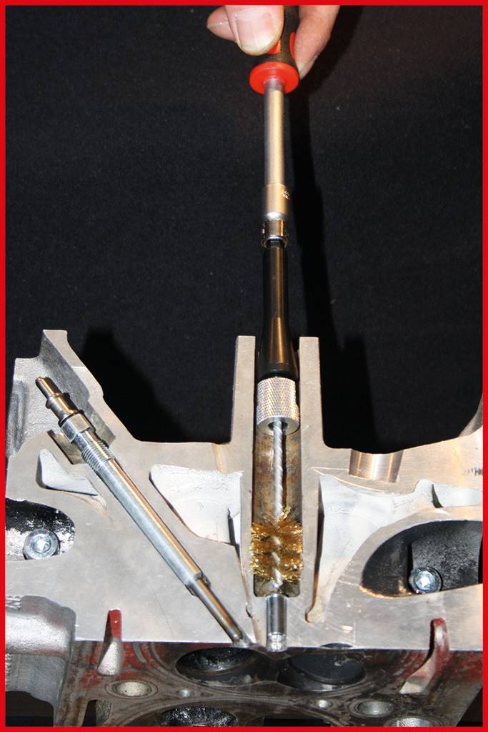 Une tige métallique et un outil sont maintenus au centre d'une structure métallique qui ressemble à une pièce de machine.