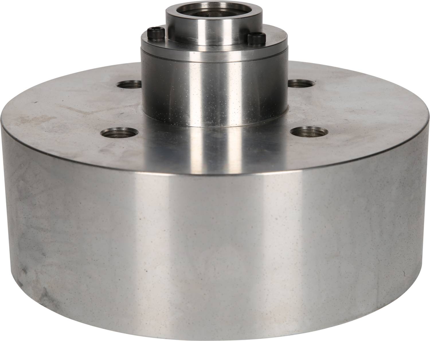 Une pièce métallique cylindrique avec plusieurs perçages sur la surface supérieure et un petit cylindre surélevé au centre.