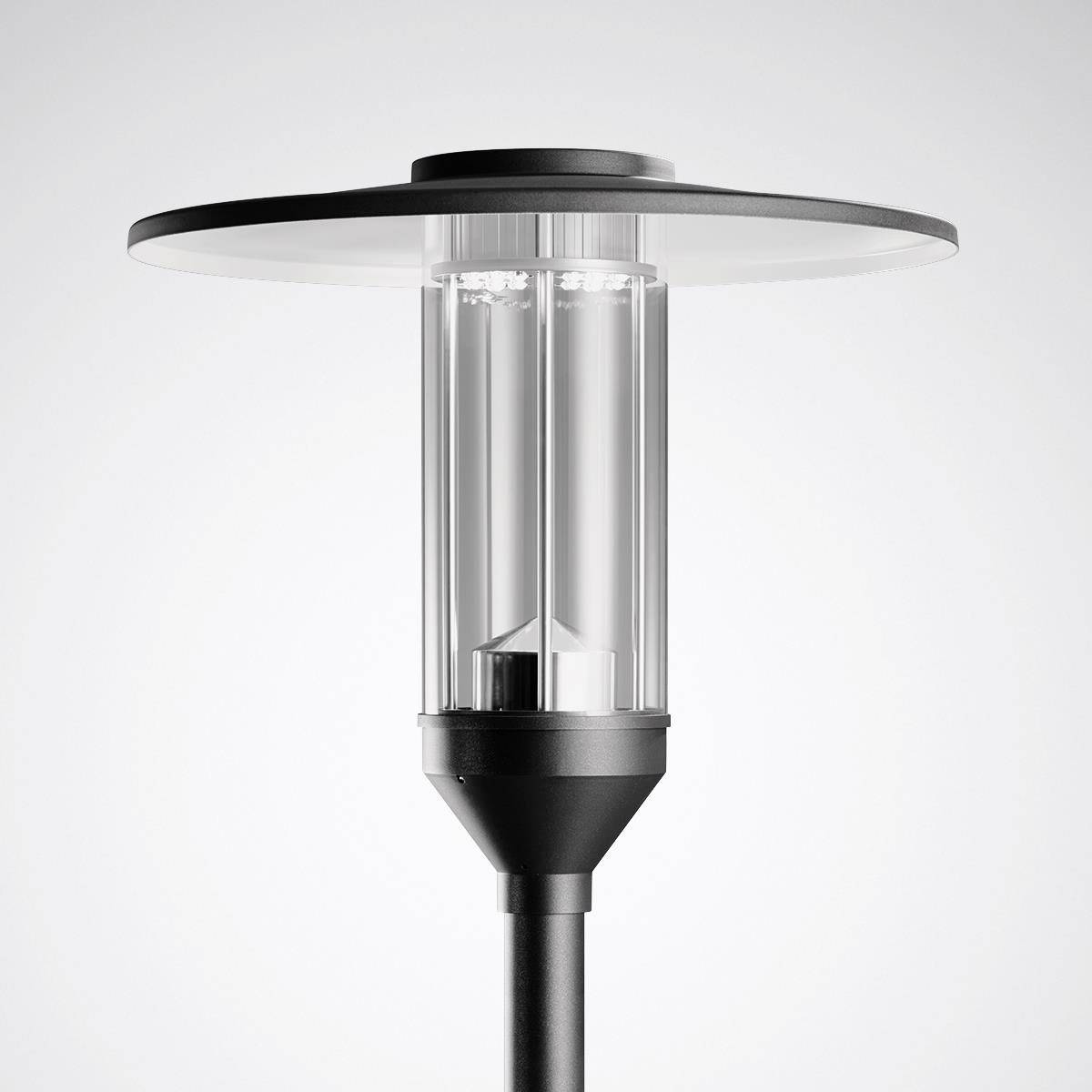 Lampadaire moderne avec boîtier transparent et abat-jour plat et rond, adapté à l'éclairage urbain.