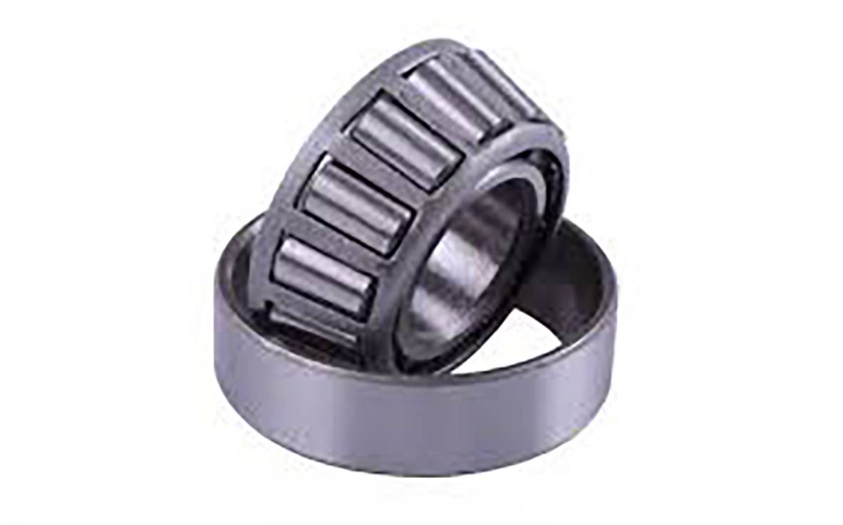 Un roulement à rouleaux conique avec des rouleaux visibles, partiellement sorti de sa bague extérieure, sur un fond blanc.