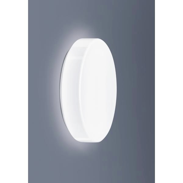 Lampe murale blanche, ronde, à surface lisse sur un fond gris. La lampe diffuse une lumière douce et adopte un design minimaliste.