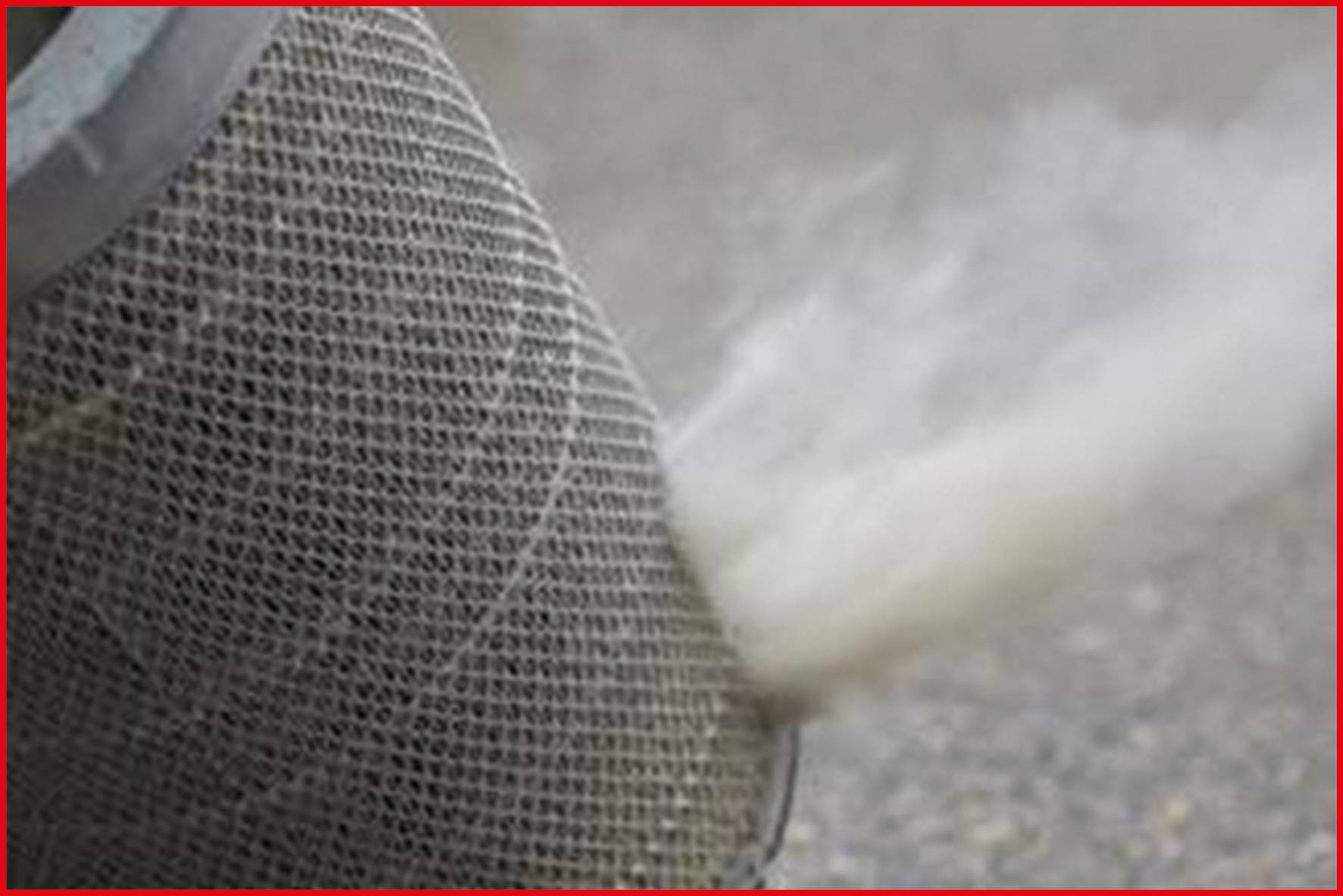 Cylindre métallique gris avec de la fumée s'échappant à travers une grille, placé sur une surface grise.