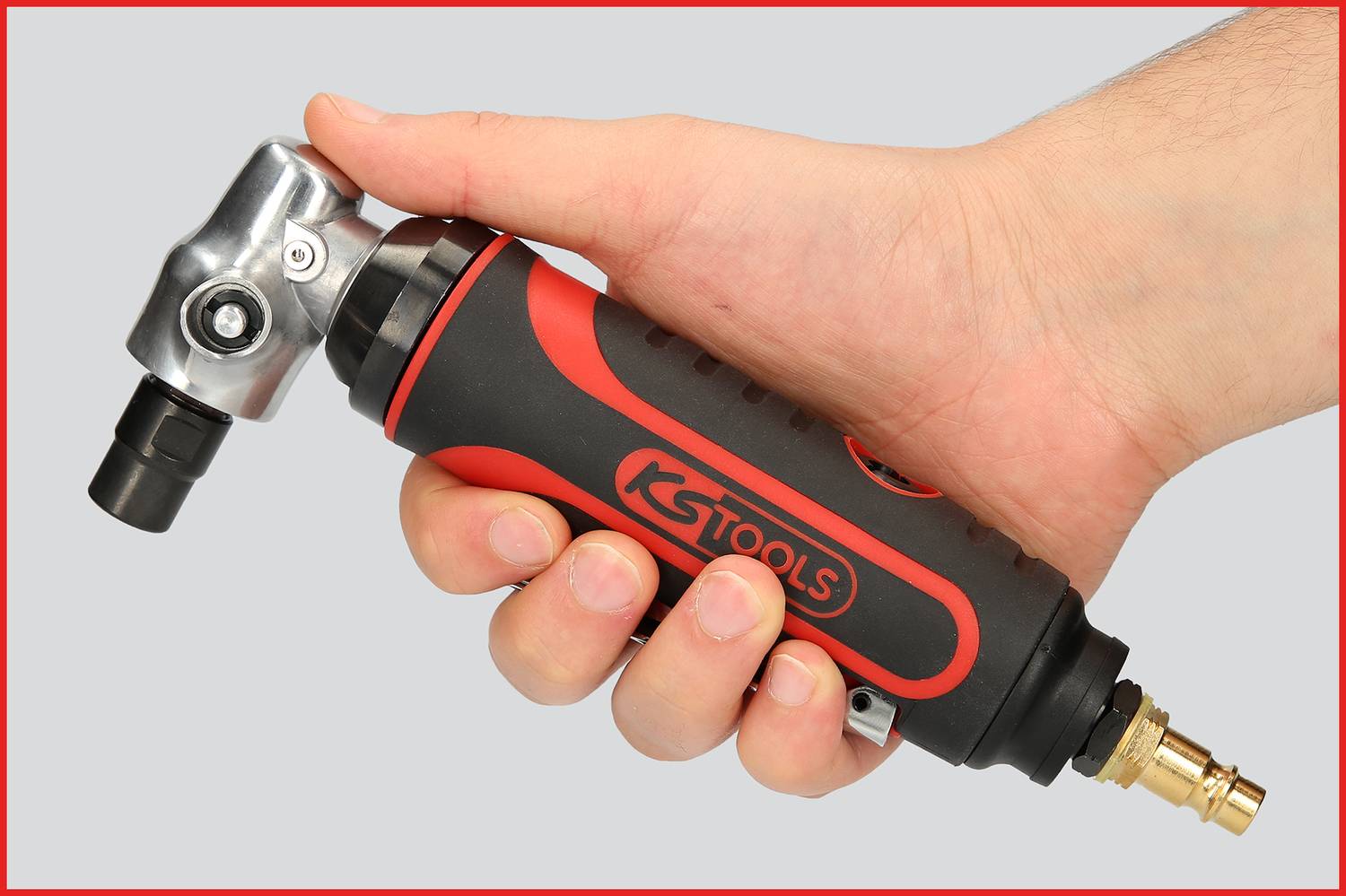 Une main tient un outil de meulage pneumatique à angle, noir avec une poignée rouge et une tête argentée, de la marque KS Tools.