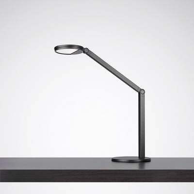 Une lampe de table moderne noire avec un bras articulé, posée sur une table en bois sombre.