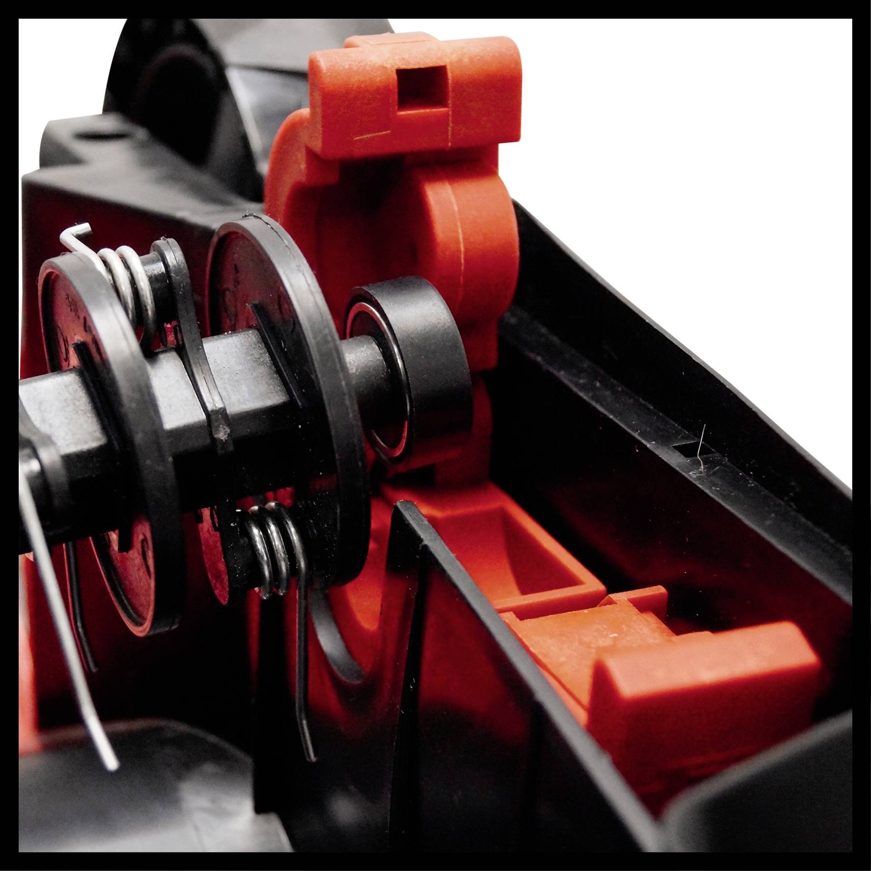 Gros plan d'un mécanisme complexe composé de pièces en plastique noir et rouge, probablement un composant d'un dispositif technique ou d'un outil.