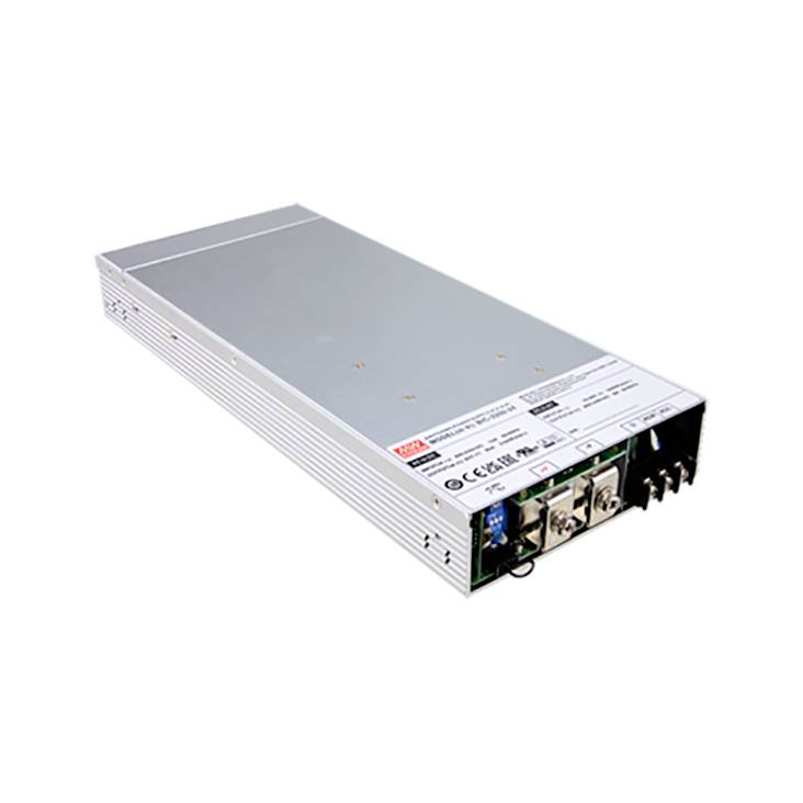 Un boîtier métallique rectangulaire avec plusieurs connexions, probablement une alimentation électrique. L'étiquette affiche des données techniques et des symboles de sécurité.