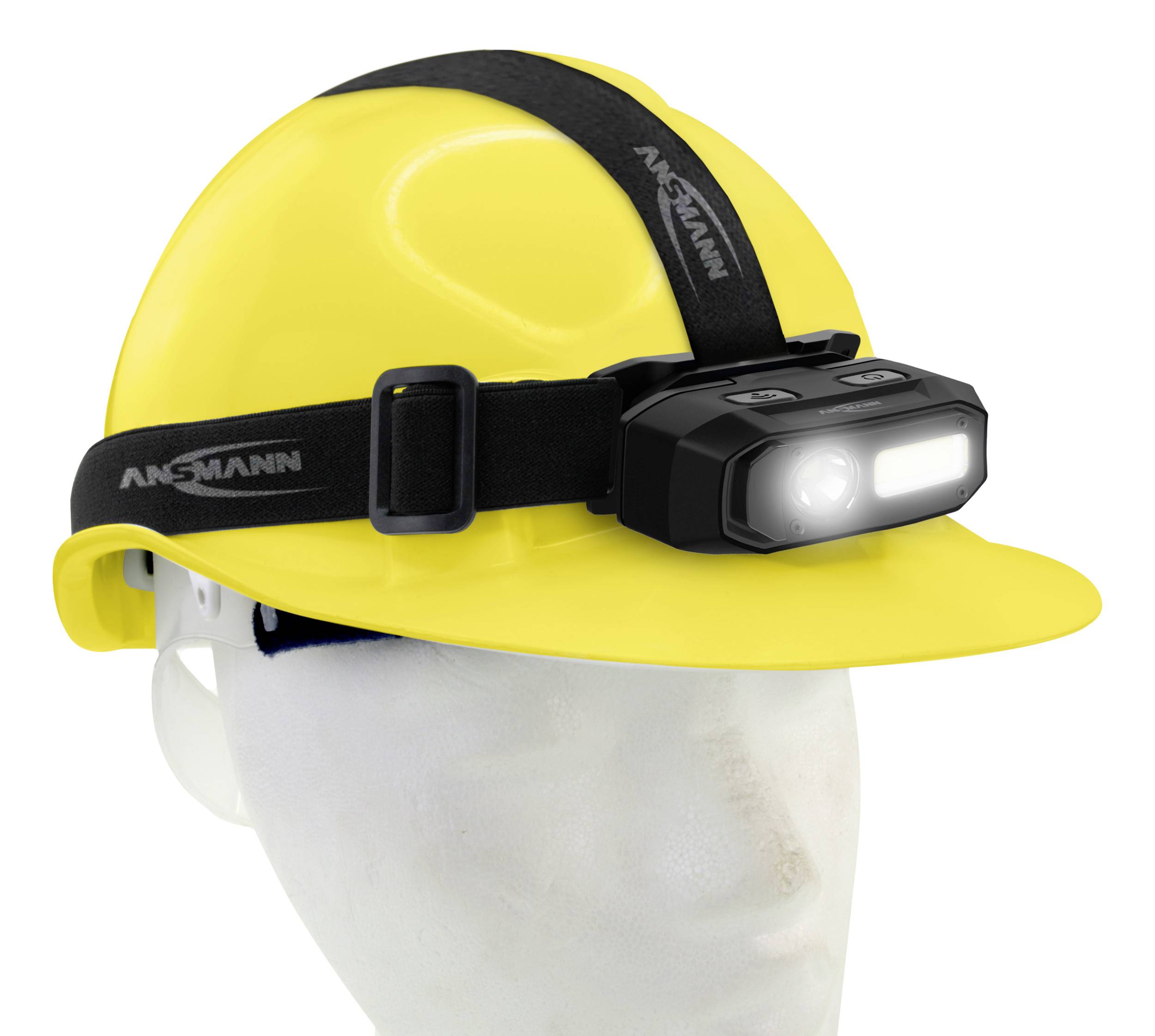 Un casque de sécurité jaune avec une lampe frontale noire montée dessus. La lampe est allumée et pointe vers l'avant.