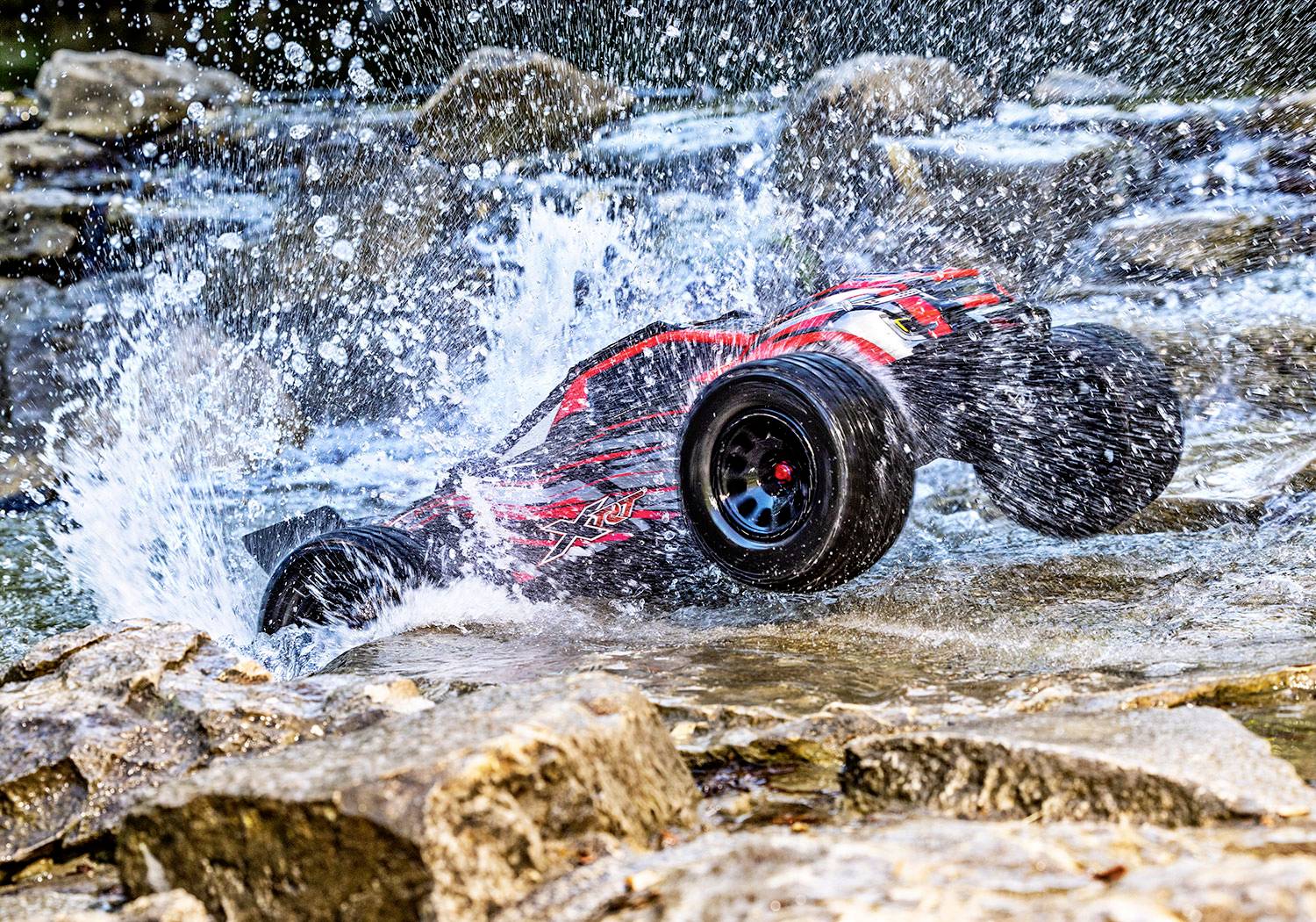 Une voiture télécommandée en plein saut au-dessus d'un cours d'eau, éclaboussant l'eau tout autour. Action dynamique dans un environnement naturel.