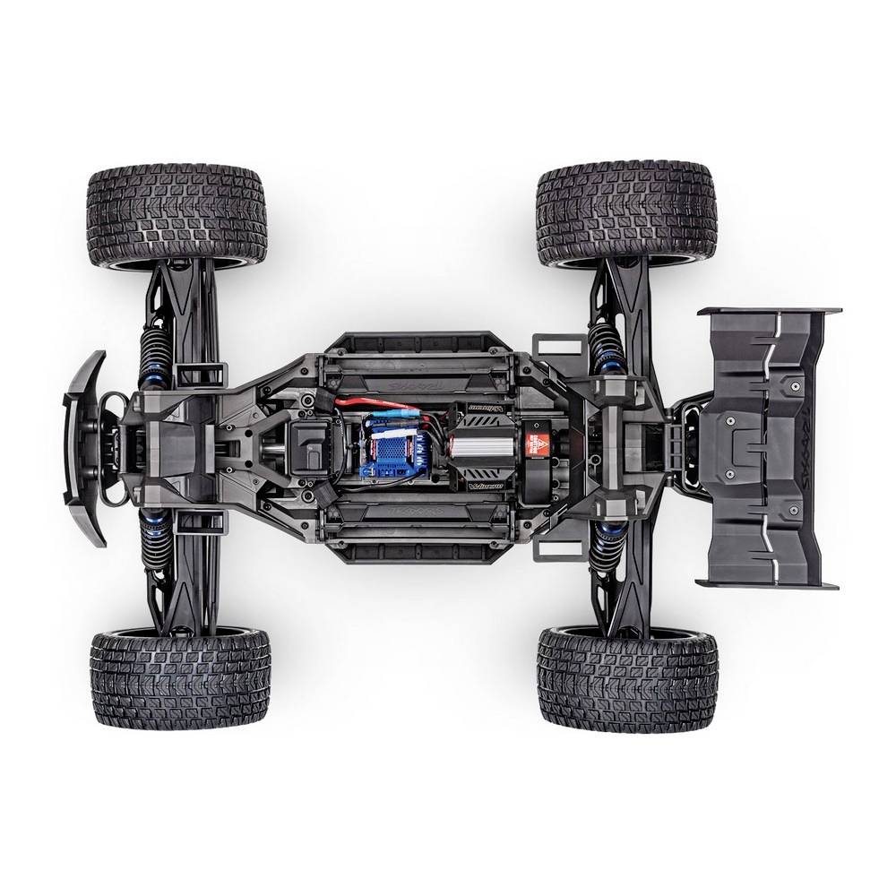 Voiture télécommandée vue de dessus ; montre le châssis, l'électronique et la suspension. Quatre grandes roues, design noir.